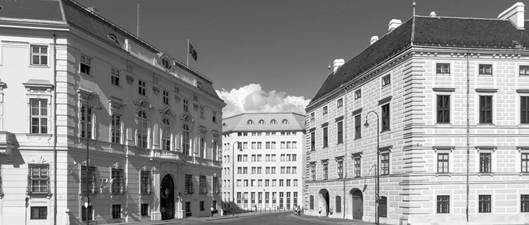 Ciemny cień padł na Ballhausplatz w Wiedniu: po lewej Kancelaria Federalna i Ministerstwo Spraw Zagranicznych, po prawej siedziba Prezydenta Federalnego.  Zieleń nie pozwala ziemi rozkwitnąć, ale pogrąża ją w chaosie, chaosie i ciemności.